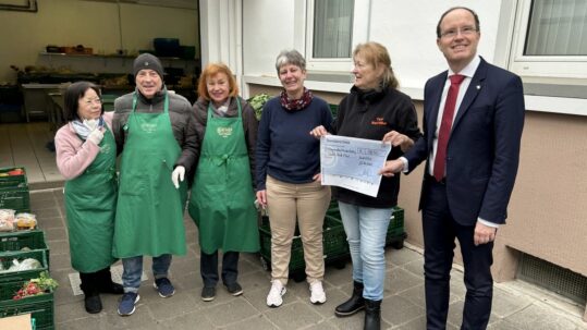 Claudia Marcks (3. v. r.) und Tobias Utter (r.) übergeben einen Scheck in Höhe von 1850 Euro an das Team der Bad Vilbeler Tafel.