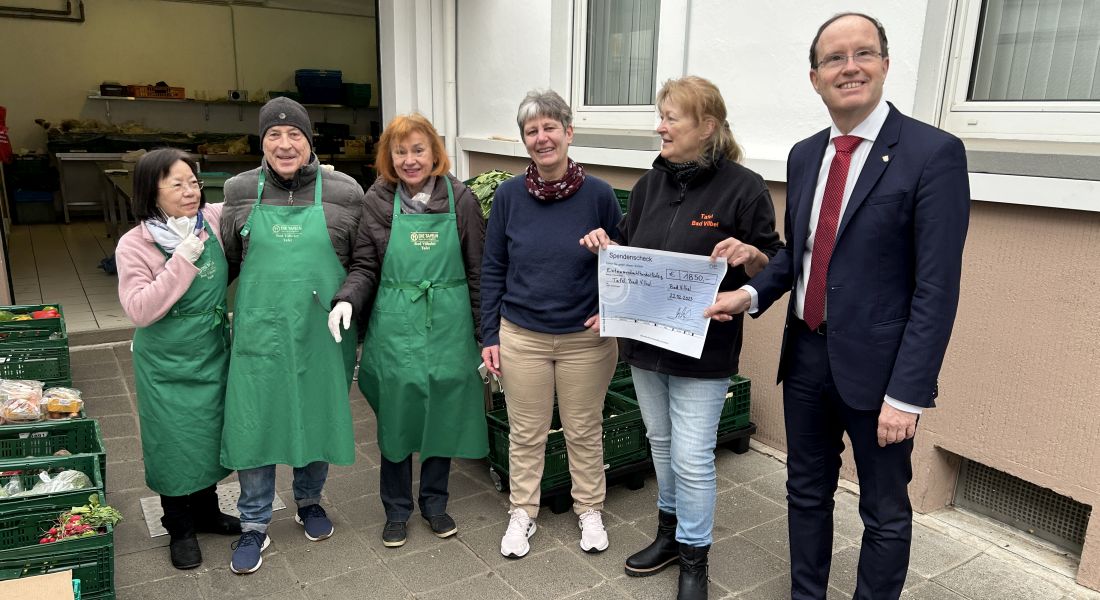 Claudia Marcks (3. v. r.) und Tobias Utter (r.) übergeben einen Scheck in Höhe von 1850 Euro an das Team der Bad Vilbeler Tafel.